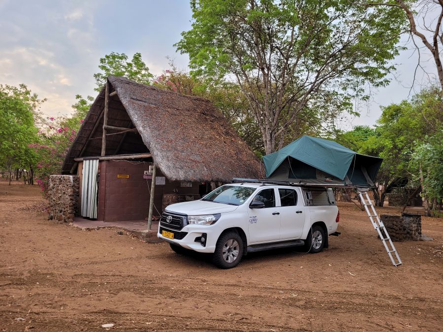 Senyati Safari Camp: unser Stellplatz mit reetgedeckter Hütte